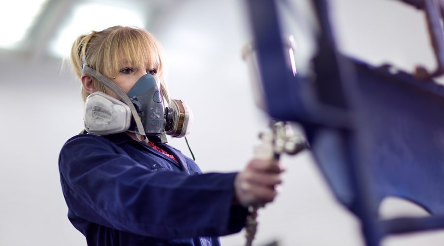 Automotive student painting car panel