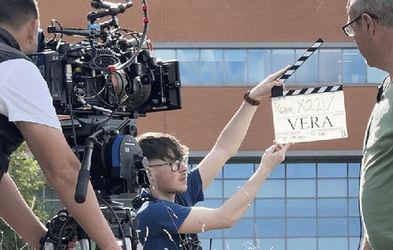 Student holding clapper board for the TV show Vera.