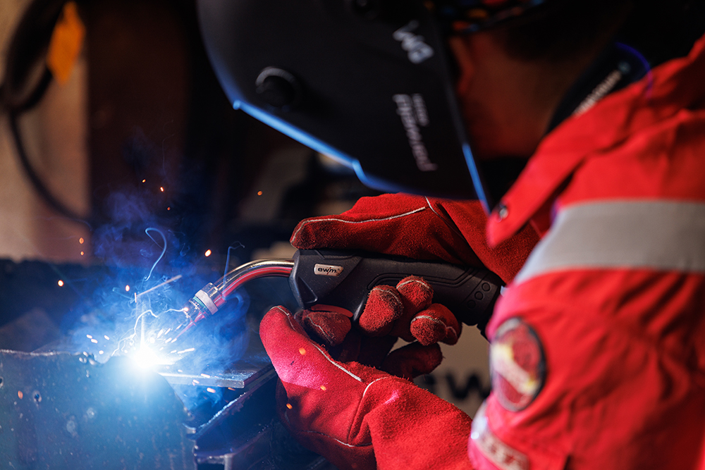 Person in full protective wear welding