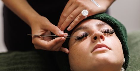 Student applying false lashes to a client