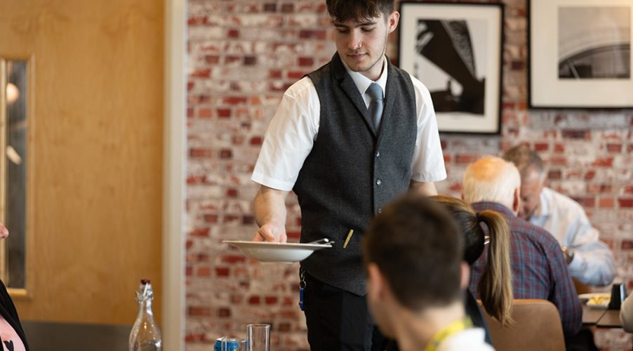 Student serving food in Enfields Kitchen