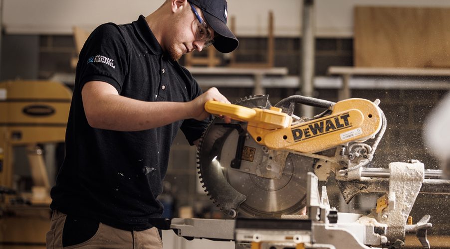 Student with safety goggles working with a saw