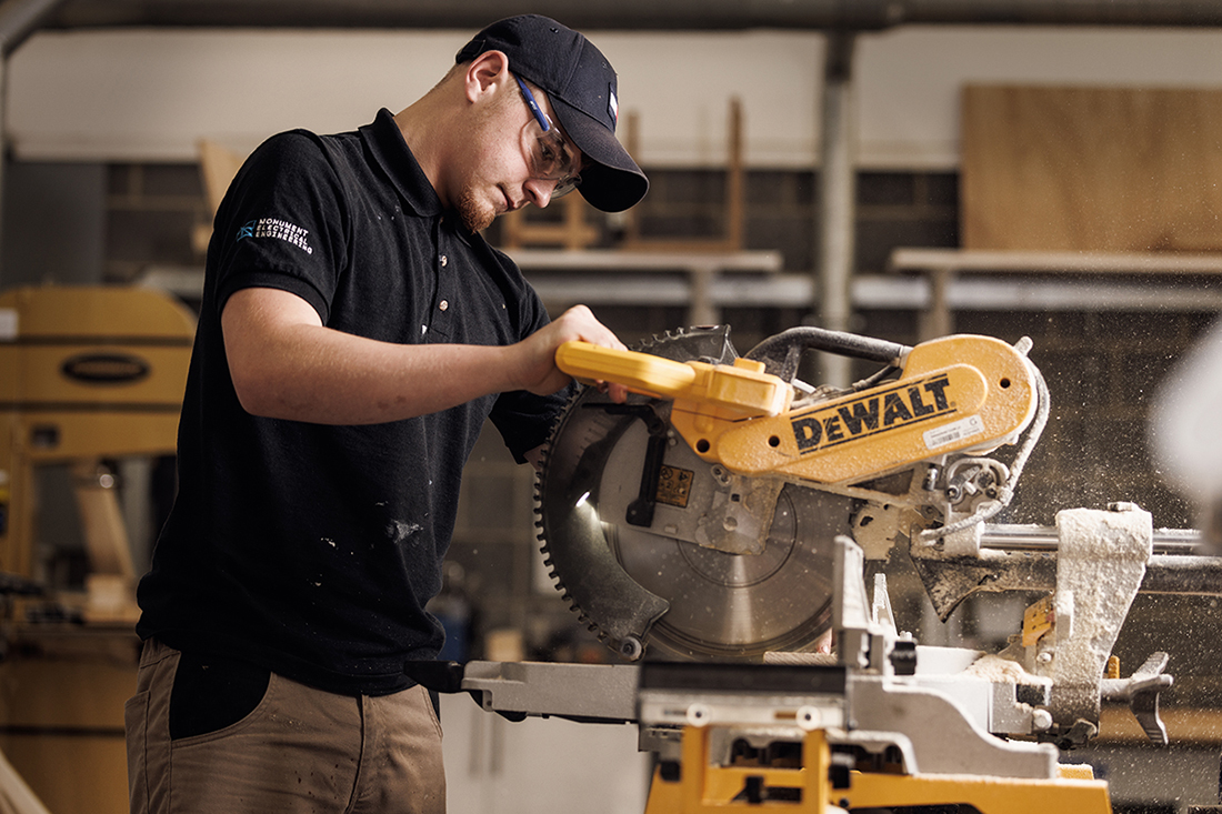 Student with safety goggles working with a saw