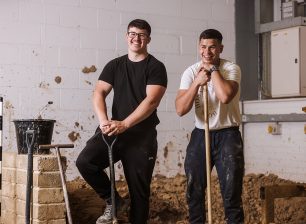 Students with shovels smiling to camera