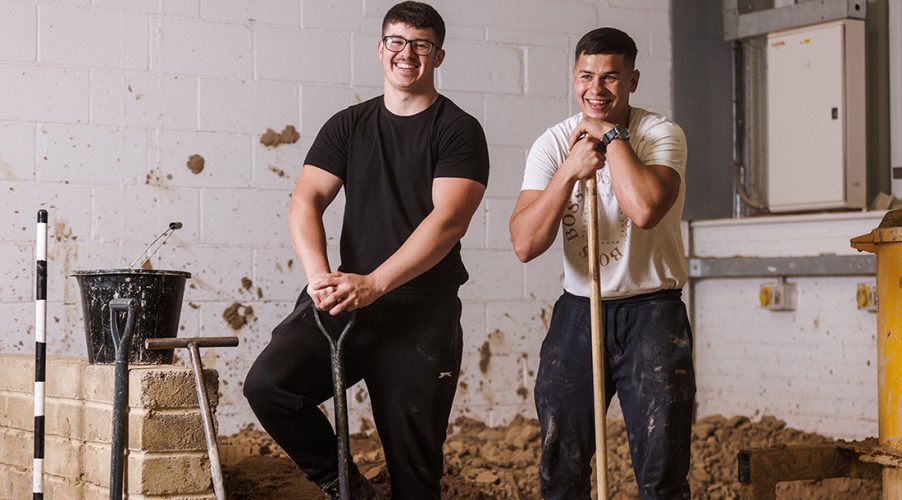 Students with shovels smiling to camera