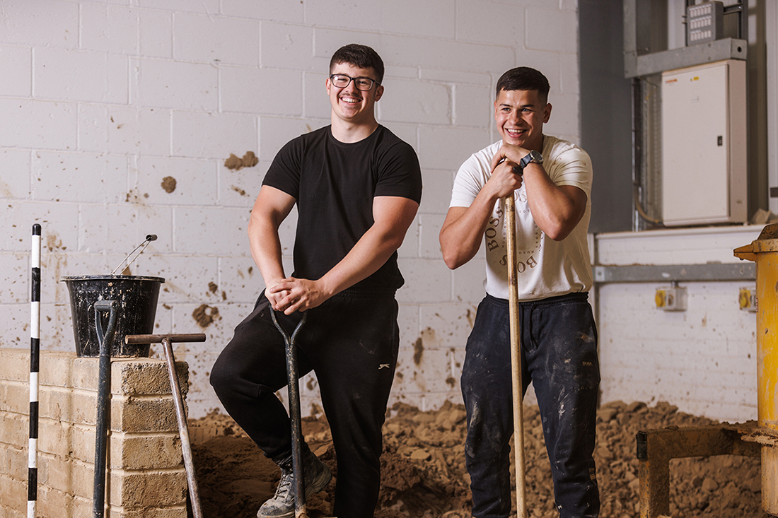 Students with shovels smiling to camera