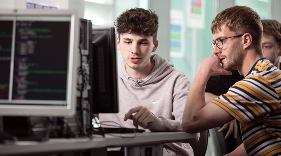 Two digital technology students working together on a computer