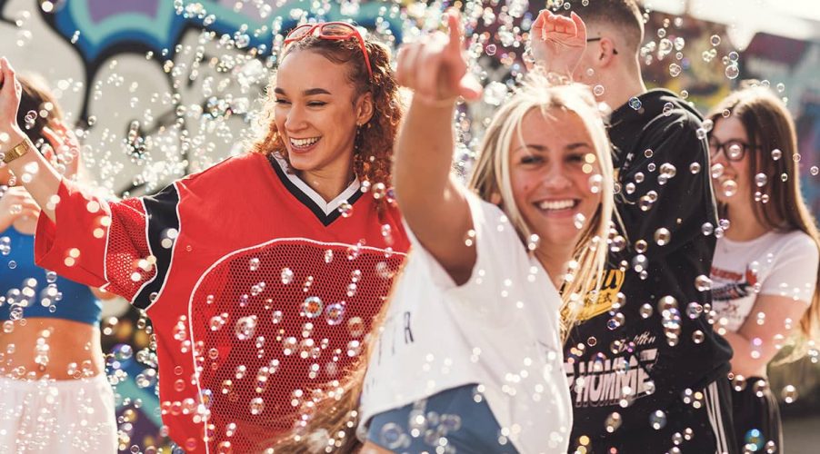 Two students having fun with bubbles floating in the air