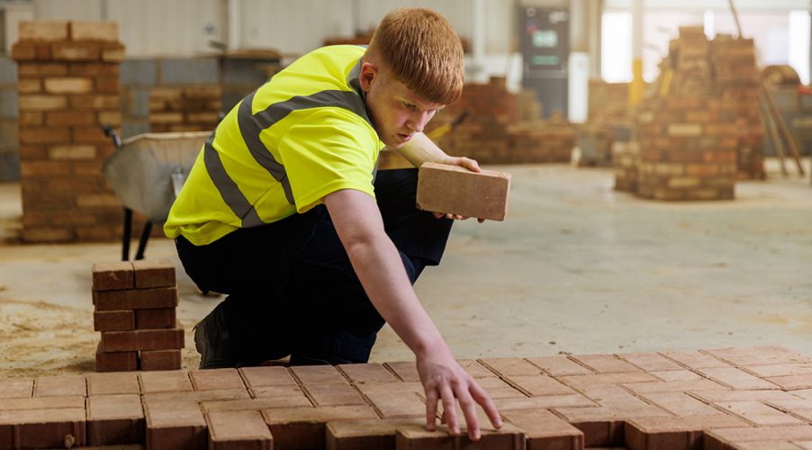 Construction student laying bricks
