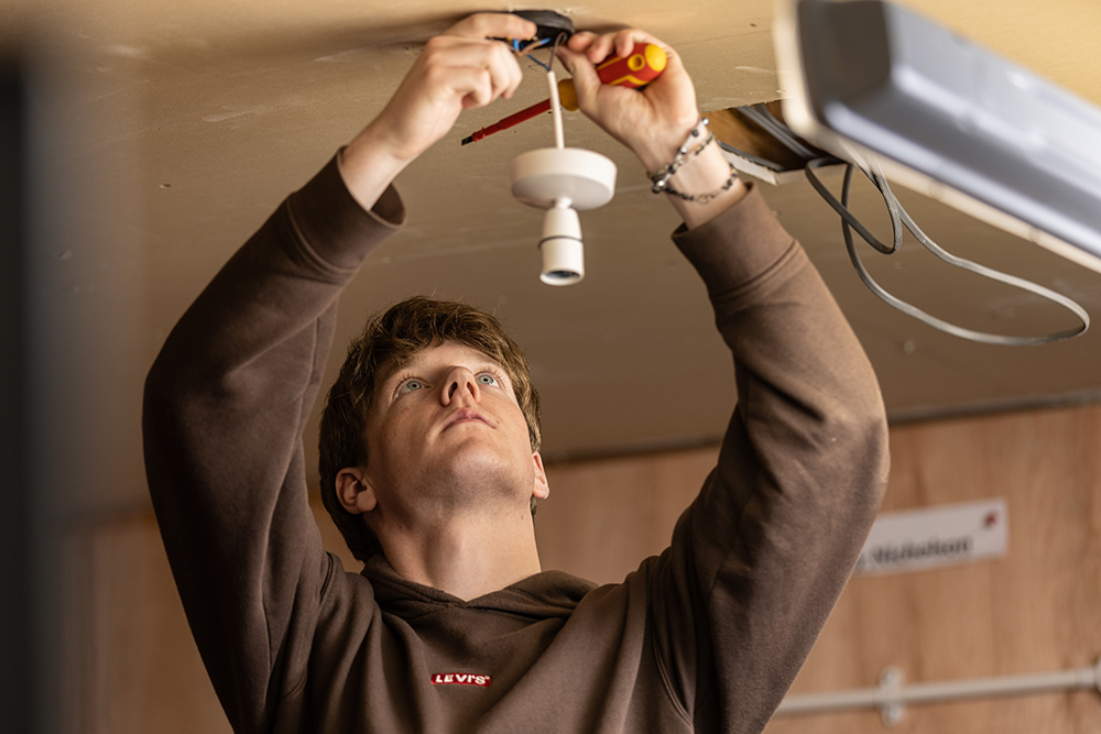 Electrical student working on a light fitting