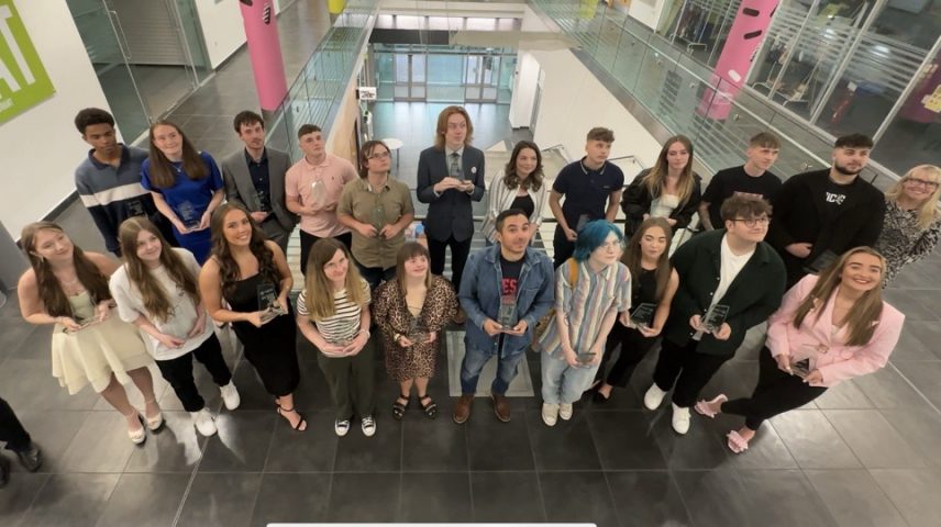 A group of students standing holding awards