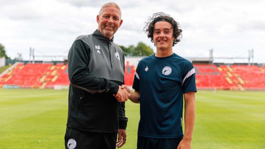 A man and a teenage boy shaking hands at a football club