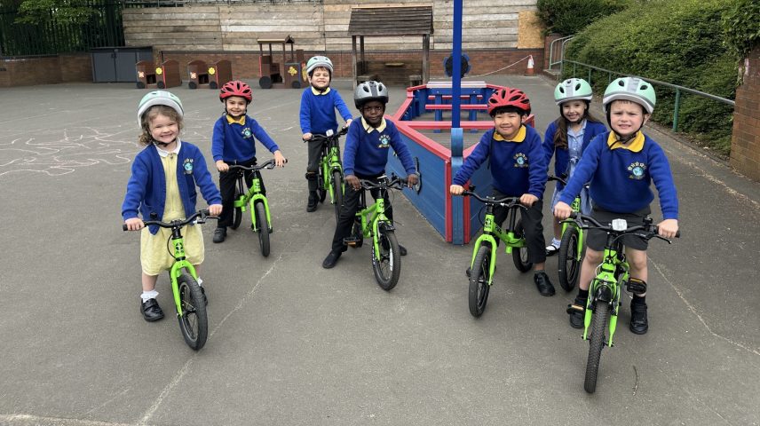 A group of primary school children riding bikes on a playground