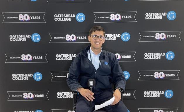 A man sitting infront of a backdrop