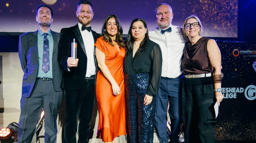 A group of men and women collecting an award on a stage