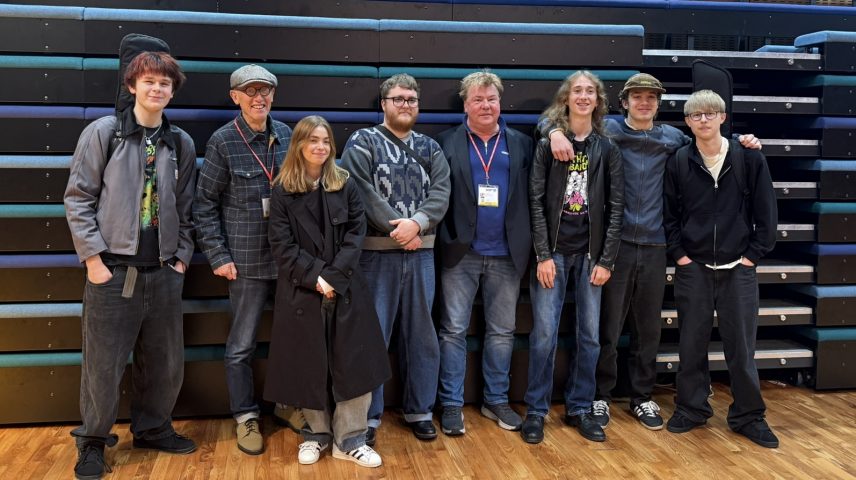 A group of people standing in front of theatre seating