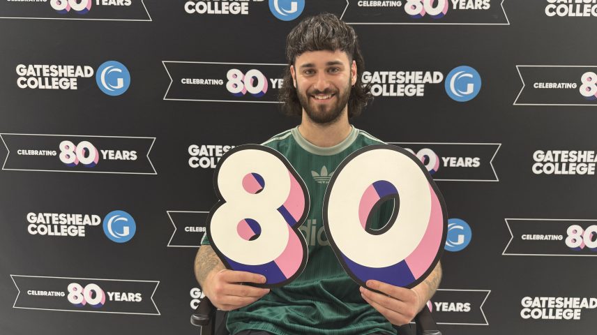 a man sitting on a chair holding a big 8 and 0