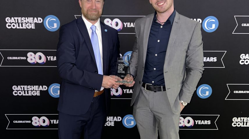 Two men standing holding an award.