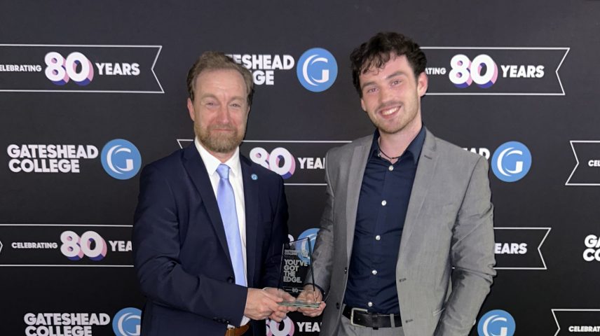 Two men standing holding an award.