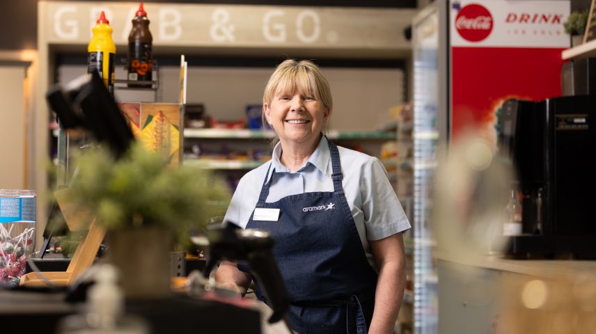 A lady standing behind the till in a shop.