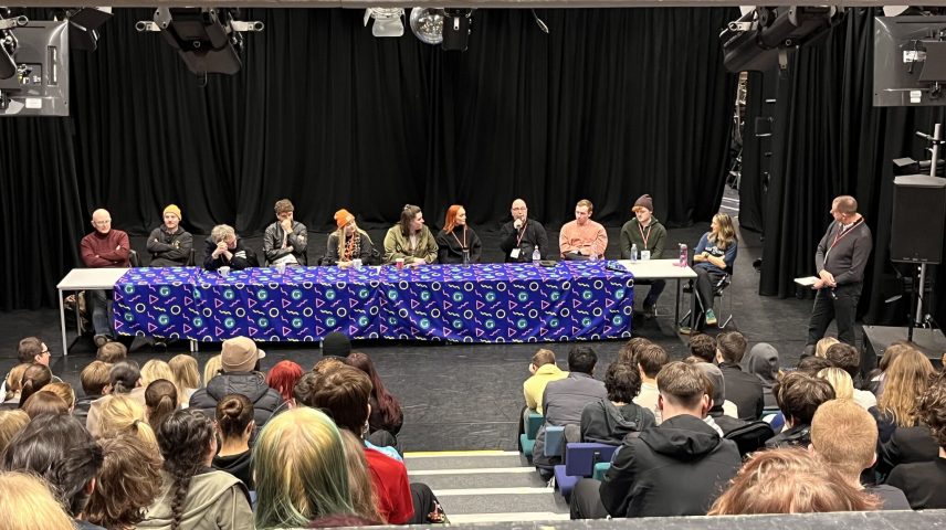 A group of people doing a panel Q and A in a theatre.