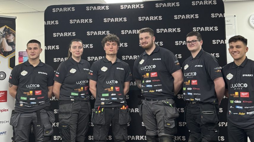 A group of men and women standing in workwear.