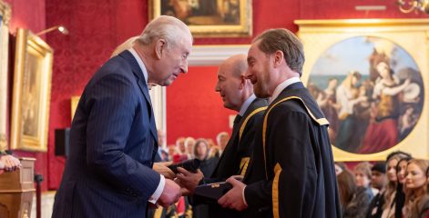 His Majesty the king presenting an award to two men.