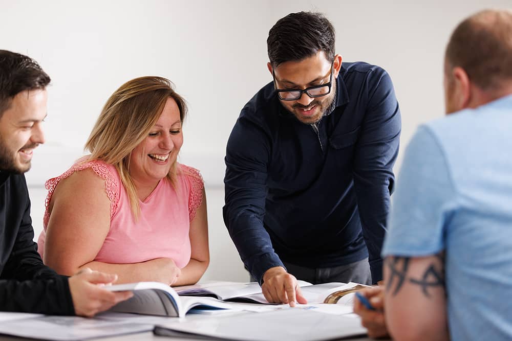 Adult students working around a table