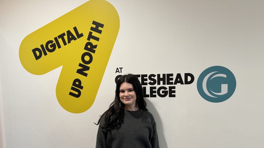 A girl standing in front of a wall that says 'Digital Up North at Gateshead College'