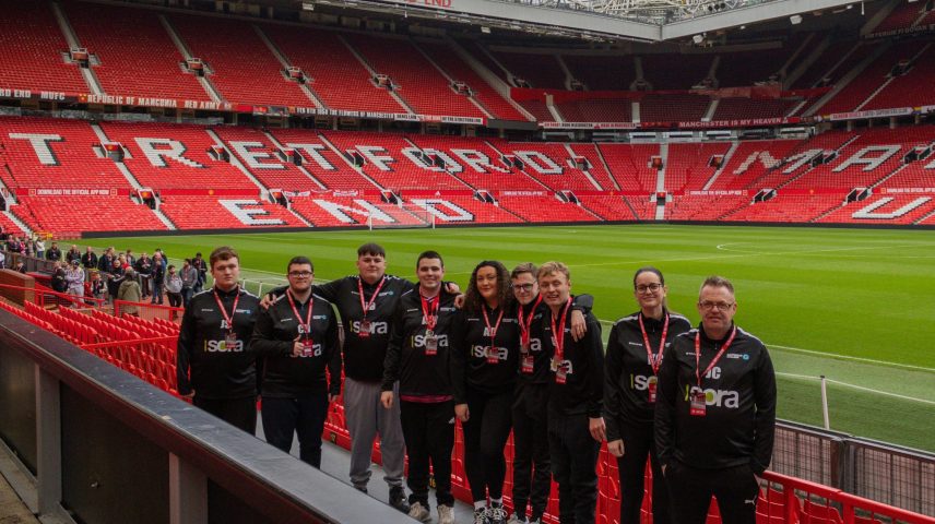 A group of people standing at Old Trafford Football Ground.